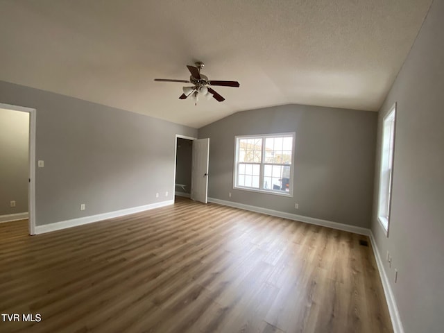 unfurnished room featuring dark hardwood / wood-style flooring, ceiling fan, and lofted ceiling