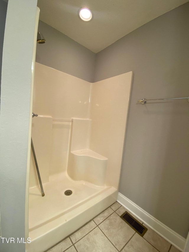 bathroom with tile patterned flooring and walk in shower