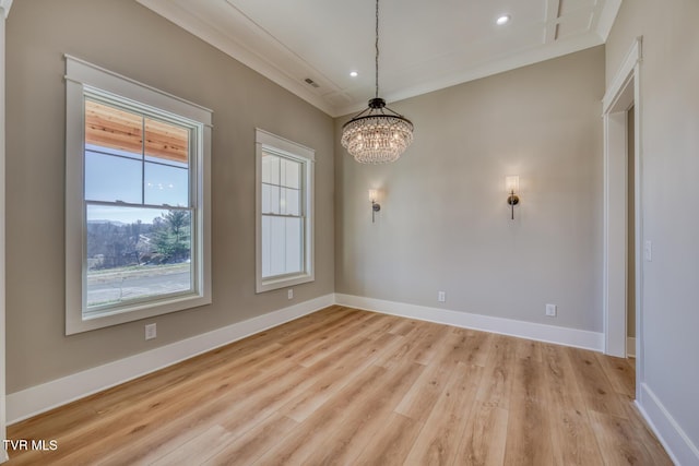 empty room with light wood-type flooring, an inviting chandelier, and crown molding