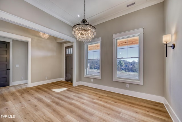 entrance foyer featuring crown molding, light hardwood / wood-style floors, and a notable chandelier