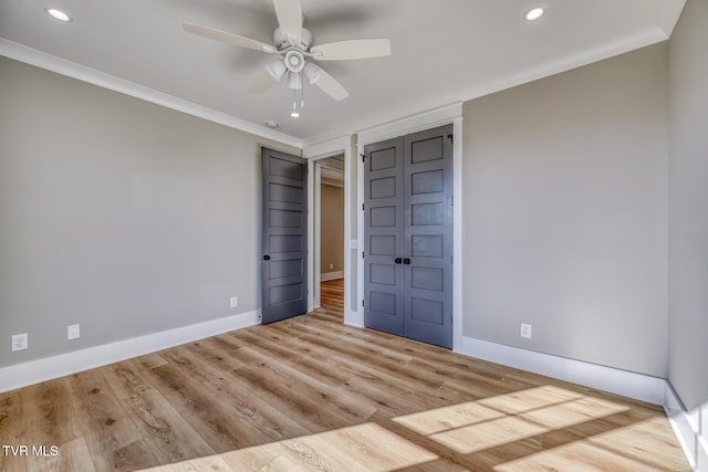 unfurnished bedroom featuring ceiling fan, a closet, ornamental molding, and light hardwood / wood-style flooring