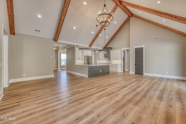 unfurnished living room featuring high vaulted ceiling, beam ceiling, an inviting chandelier, and light hardwood / wood-style flooring