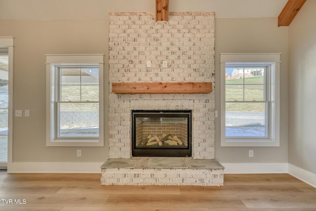 interior details with wood-type flooring and a brick fireplace