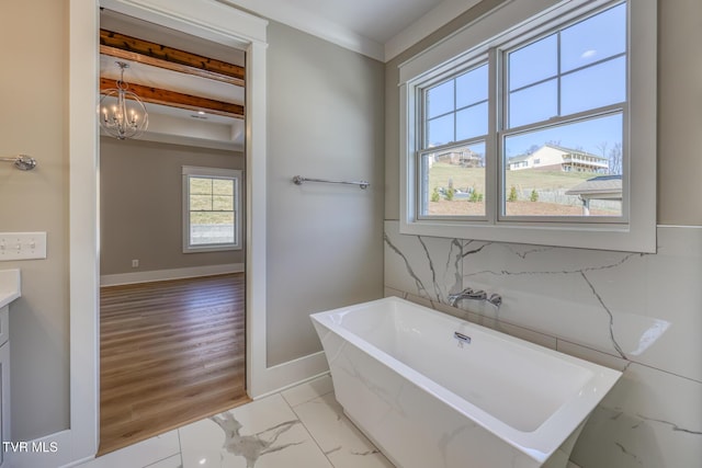 bathroom featuring vanity, a bathtub, beamed ceiling, and an inviting chandelier