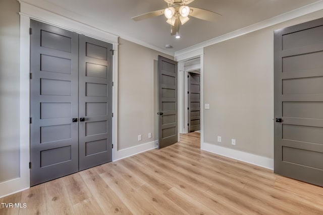 unfurnished bedroom featuring ceiling fan, a closet, light wood-type flooring, and crown molding