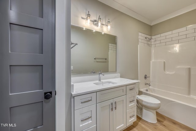 full bathroom featuring toilet, hardwood / wood-style floors, crown molding, tub / shower combination, and vanity