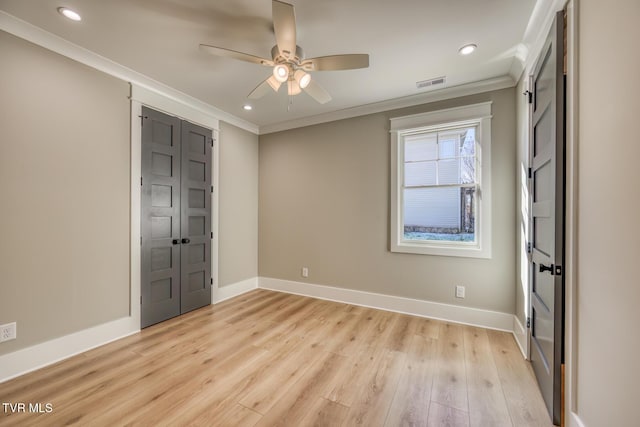 unfurnished bedroom with ceiling fan, a closet, crown molding, and light hardwood / wood-style flooring