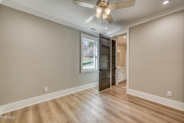 unfurnished bedroom featuring ceiling fan, ensuite bathroom, ornamental molding, and light wood-type flooring