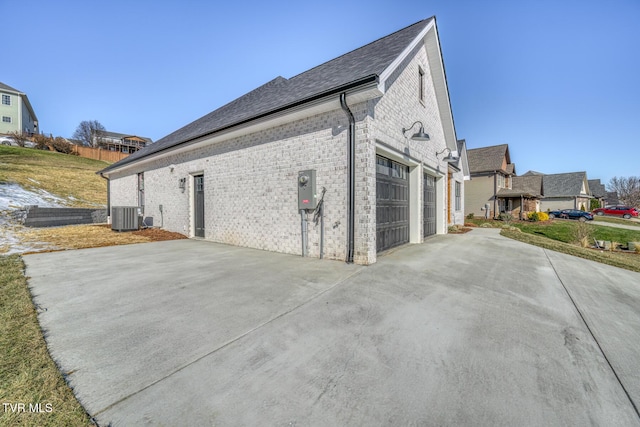 view of side of home featuring a garage and central AC unit