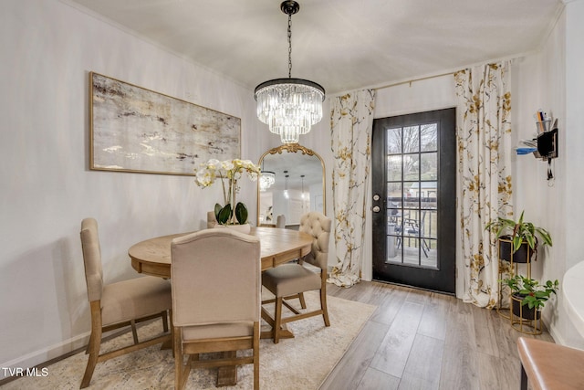 dining space with a chandelier and light wood-type flooring