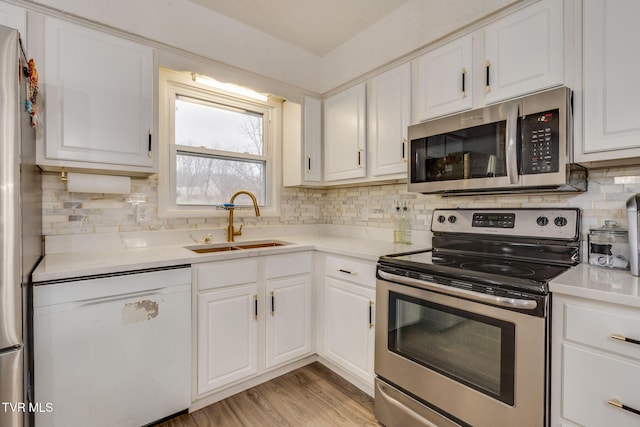 kitchen with light hardwood / wood-style floors, sink, white cabinetry, and stainless steel appliances