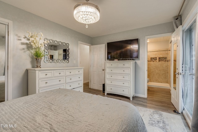 bedroom featuring a chandelier, connected bathroom, and light hardwood / wood-style flooring