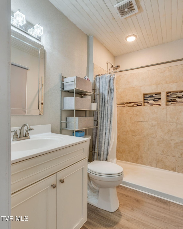 bathroom with curtained shower, vanity, wood-type flooring, and toilet