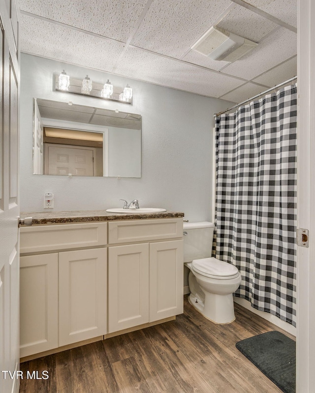 bathroom with a paneled ceiling, vanity, toilet, and hardwood / wood-style flooring