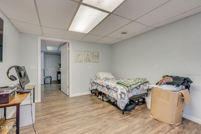 bedroom featuring a drop ceiling and wood-type flooring