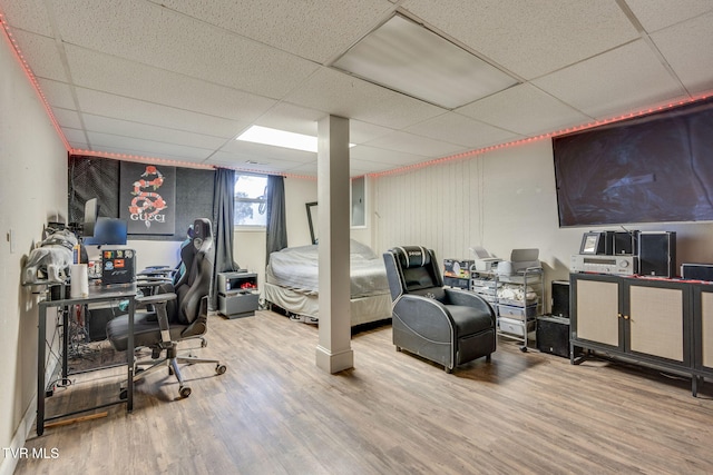 bedroom with a paneled ceiling and hardwood / wood-style flooring