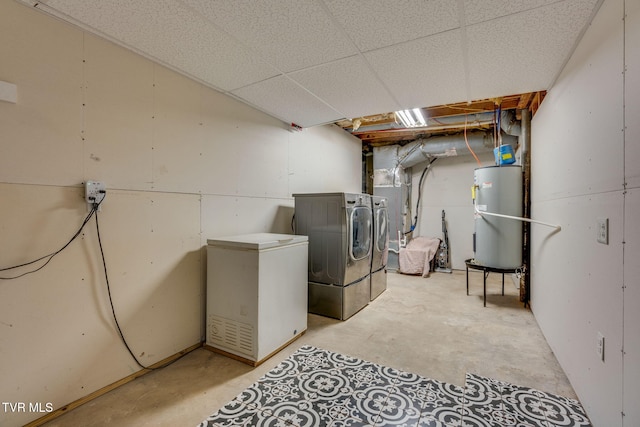 basement featuring a paneled ceiling, washer and dryer, fridge, and water heater