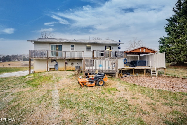 rear view of house featuring a wooden deck and a yard