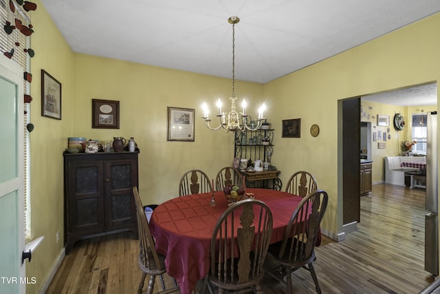 dining space with a notable chandelier and dark hardwood / wood-style flooring