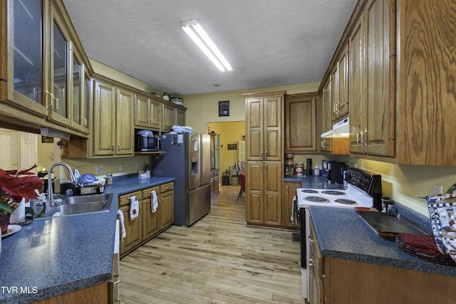 kitchen featuring sink, white electric stove, stainless steel refrigerator with ice dispenser, light wood-type flooring, and a textured ceiling