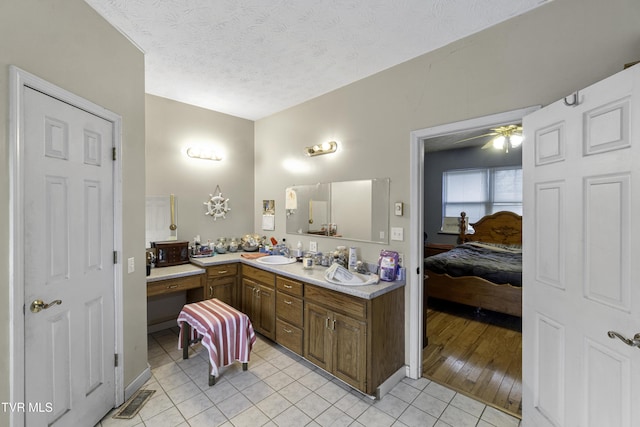 bathroom with tile patterned flooring, ceiling fan, a textured ceiling, and vanity