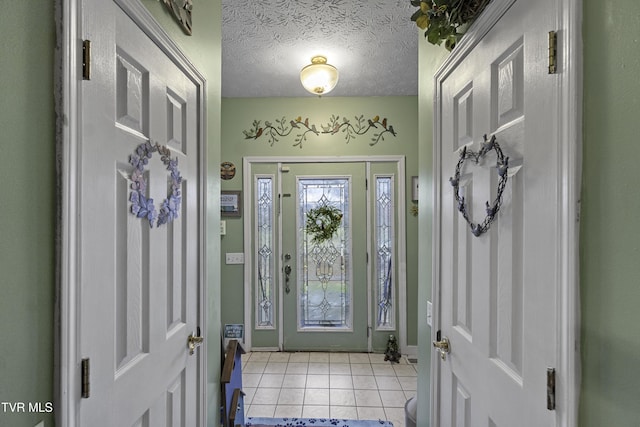 foyer entrance featuring light tile patterned floors and a textured ceiling