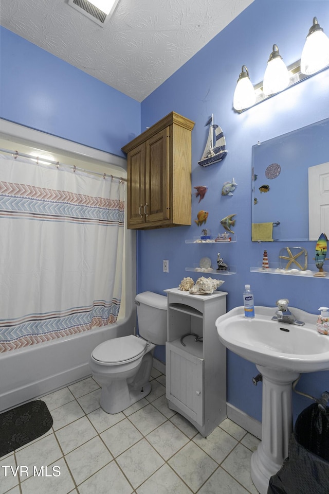 bathroom featuring tile patterned flooring, shower / bath combination with curtain, toilet, and a textured ceiling