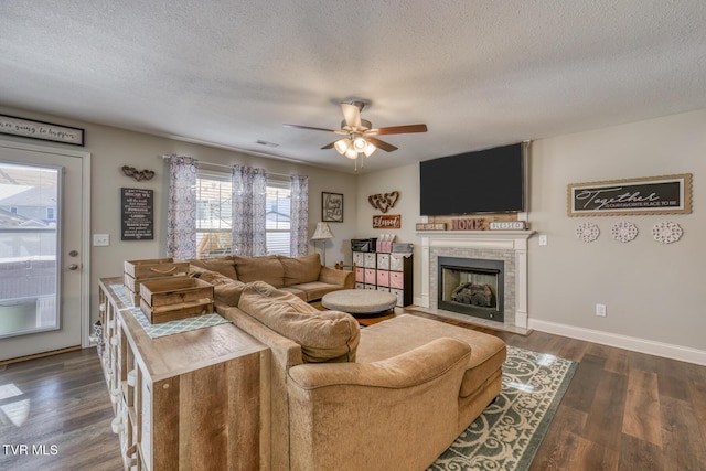 living room with ceiling fan, dark hardwood / wood-style flooring, and a textured ceiling