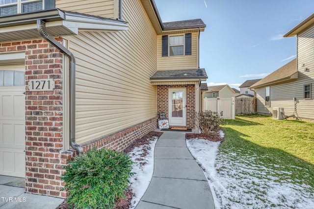 property entrance featuring a yard, a garage, and central AC