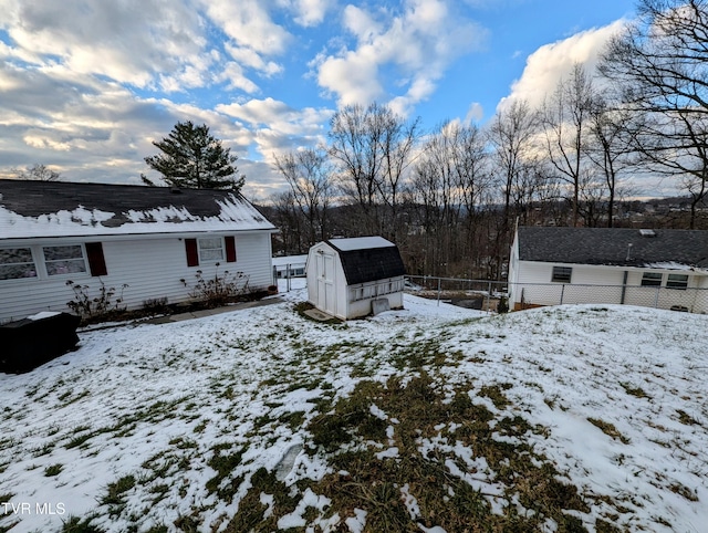 yard covered in snow featuring a storage unit