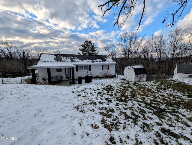 snow covered property with a storage unit