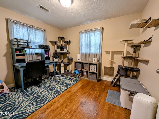 home office with a textured ceiling and hardwood / wood-style floors