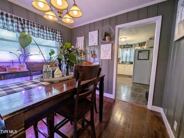 dining room featuring hardwood / wood-style floors, crown molding, and a chandelier