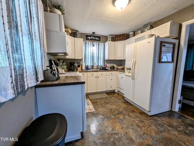 kitchen with sink, white appliances, a textured ceiling, and white cabinets