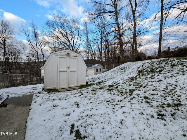 snowy yard with a shed