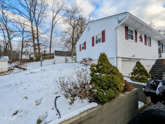 view of snow covered exterior featuring a garage