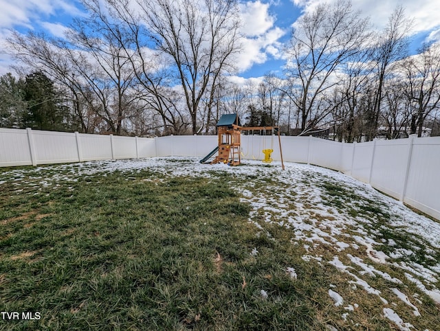 yard layered in snow featuring a playground