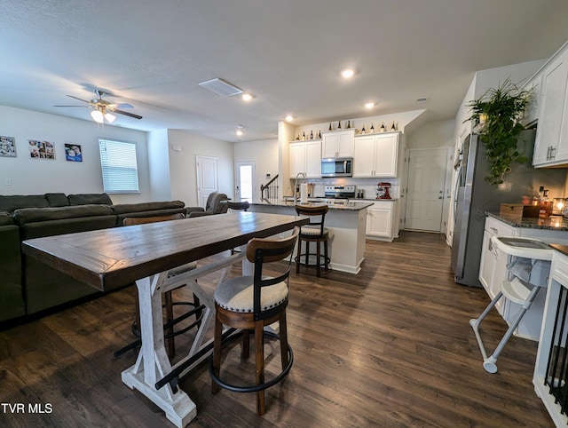 dining area featuring ceiling fan and dark hardwood / wood-style flooring