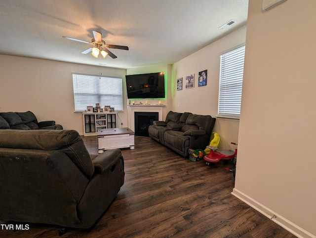 living room featuring ceiling fan and dark hardwood / wood-style flooring