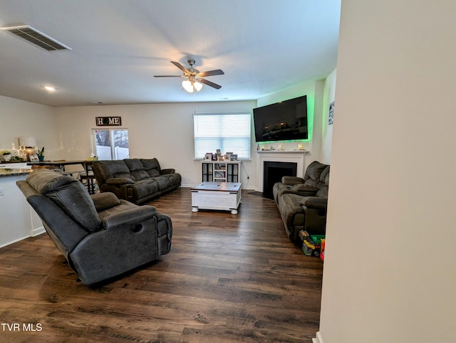 living room featuring ceiling fan and dark hardwood / wood-style flooring