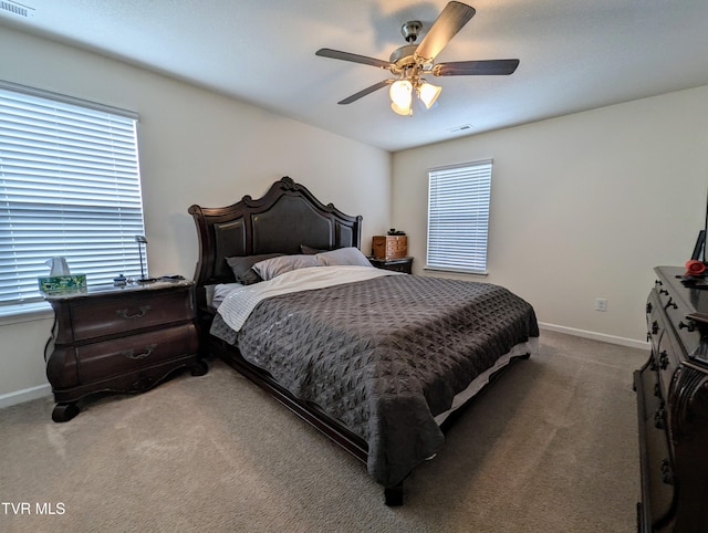 carpeted bedroom featuring multiple windows and ceiling fan