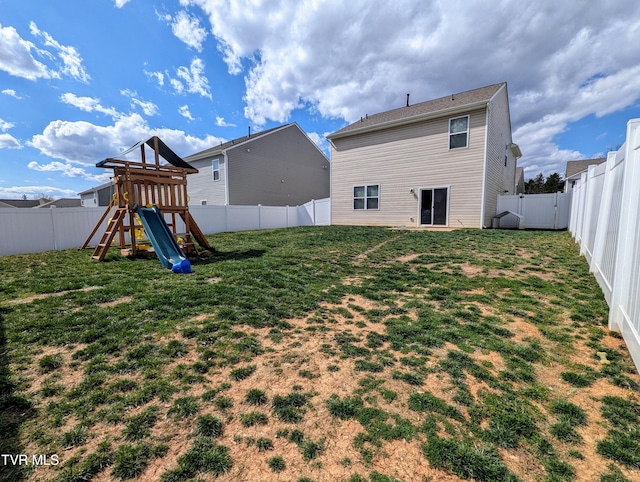 back of property with a yard, a fenced backyard, and a playground