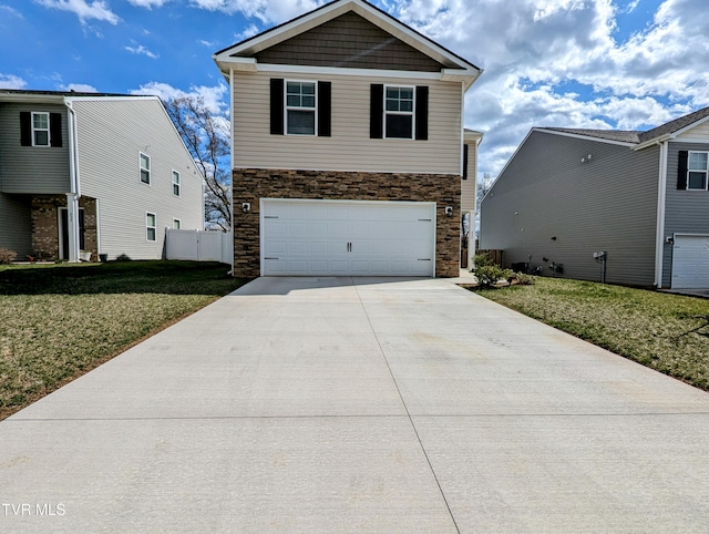 traditional-style home with stone siding, a front yard, concrete driveway, and an attached garage