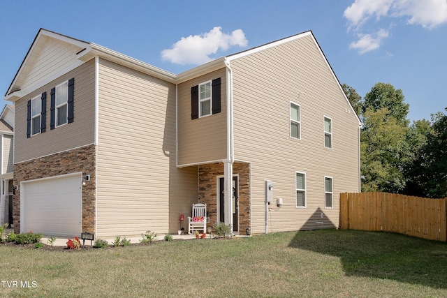 back of house with a garage and a yard