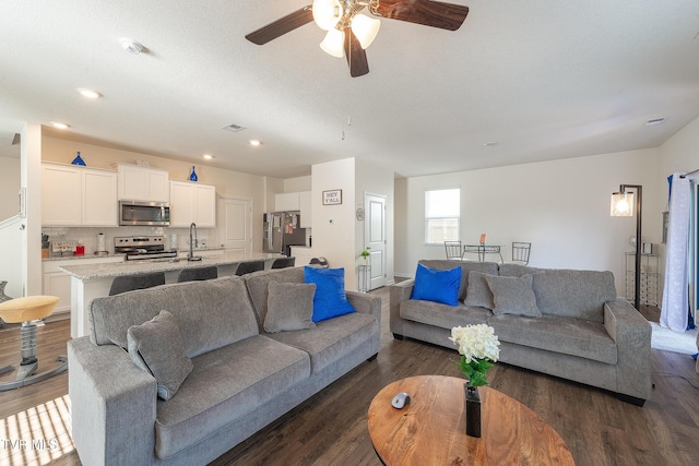 living room featuring a textured ceiling, ceiling fan, and dark hardwood / wood-style floors