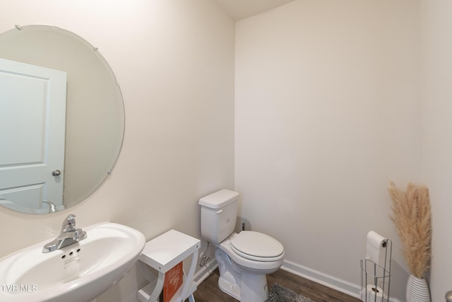 bathroom with hardwood / wood-style floors, toilet, and sink