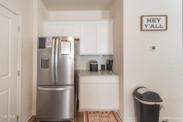 kitchen with white cabinets, stainless steel fridge with ice dispenser, and backsplash