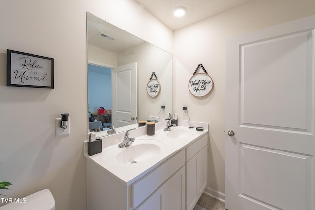 bathroom with a textured ceiling and vanity