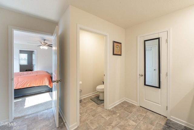 interior space featuring ceiling fan and toilet