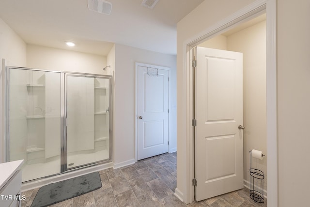 bathroom with vanity and a shower with door